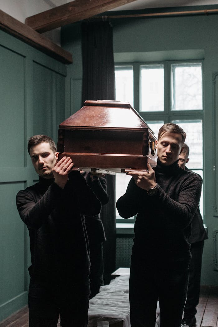 Karen Acres Celebrant A Group of Men in Black Clothing Carrying a Wooden Coffin